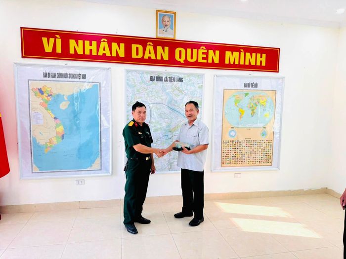 Thiếu tá Phạm Văn Công trao trả hơn 219 triệu đồng cho ông Vũ Văn Phòng. Ảnh: Ban CHQS xã Tiên Lãng.