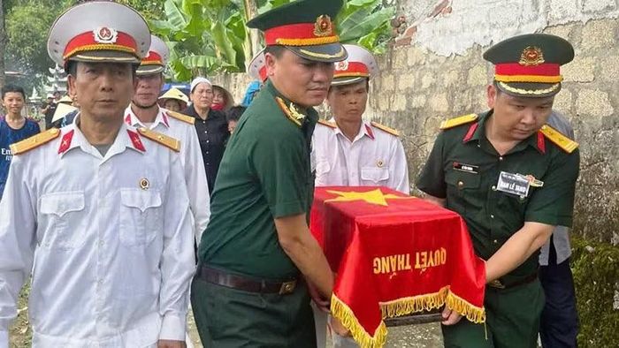 Lực lượng vũ trang cùng các cựu chiến binh di chuyển hài cốt liệt sĩ.
