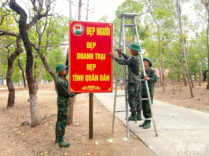 Chiến sĩ Trung đoàn 66 chỉnh sửa hệ thống pa nô, bảng biểu. Ảnh: VĂN THƯỢNG 