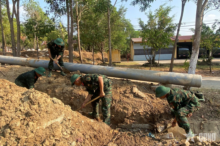 Cán bộ, chiến sĩ Trung đoàn 66 đào rãnh, củng cố hệ thống thoát nước. Ảnh: VĂN THƯỢNG 