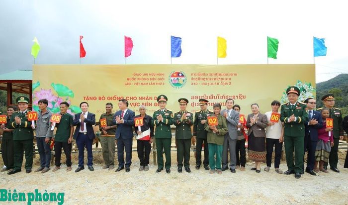 Đại tướng Phan Văn Giang và Đại tướng Khăm Liêng-Ụ Thạ Cay Sỏn cùng các đại biểu trao tặng bò giống cho các hộ gia đình có hoàn cảnh khó khăn tại khu vực biên giới Lào. Ảnh: Khánh Toàn