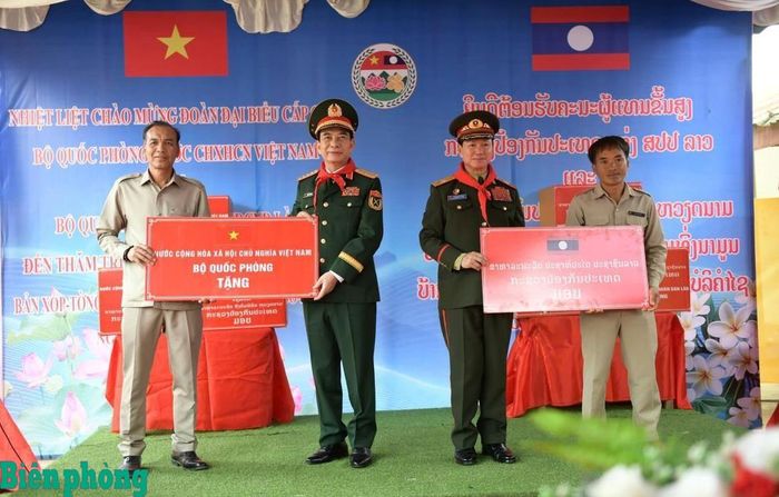 Đại tướng Phan Văn Giang và Đại tướng Khăm Liêng-Ụ Thạ Cay Sỏn tặng quà giáo viên, học sinh Trường Tiểu học Thông Năm Mun, bản Xốp Tờng, xã Nậm On, huyện Xay Chăm Phon, tỉnh Bô Ly Khăm Xay (Lào). Ảnh: Lam Giang
