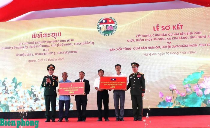 Đại tướng Phan Văn Giang và Đại tướng Khăm Liêng-Ụ Thạ Cay Sỏn tặng quà đại diện Ban quản lý thôn Thủy Phong, xã Kim Bảng, tỉnh Nghệ An (Việt Nam) và bản Xốp Tờng, xã Nặm On, huyện Xay Chăm Phon, tỉnh Bô Ly Khăm Xay (Lào) tại Lễ sơ kết kết nghĩa cụm dân cư hai bên biên giới. Ảnh: Viết Lam