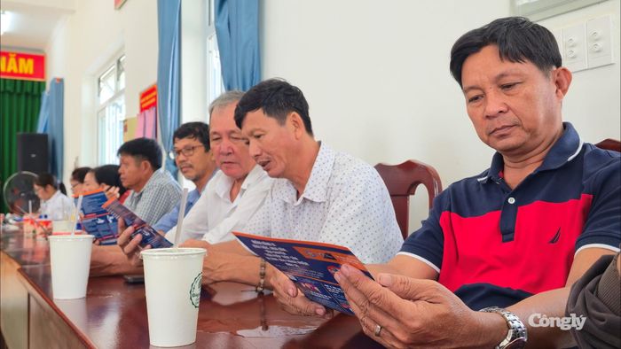 Ngư dân tìm hiểu các quy định của pháp luật trên tờ rơi.