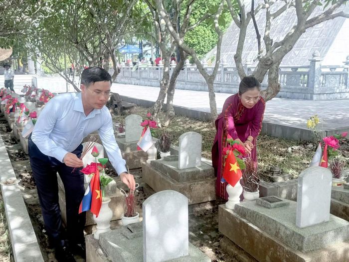 Đồng chí Phạm Đức Ấn, Ủy viên Ban Chấp hành Trung ương Đảng, Thống đốc Ngân hàng Nhà nước Việt Nam và đồng chí Võ Thị Minh Sinh, Phó Bí thư Tỉnh ủy, Chủ tịch Ủy ban MTTQ Việt Nam tỉnh Nghệ An dâng hương trước các phần mộ liệt sĩ tại Nghĩa trang Liệt sĩ Quốc tế Việt - Lào.