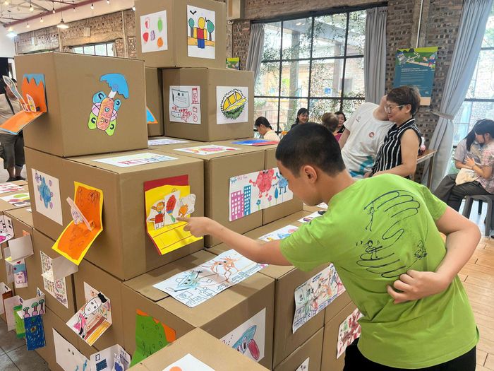 Các em nhỏ háo hức ngắm tác phẩm do chính mình sáng tạo được trưng bày tại triển lãm.