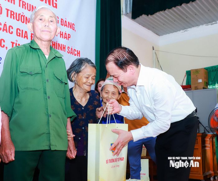 Đồng chí Hoàng Thanh Tùng - Ủy viên Trung ương Đảng, Bộ trưởng Bộ Tư pháp tặng quà đến gia đình chính sách xã Giai Lạc. Ảnh: Thành Duy
