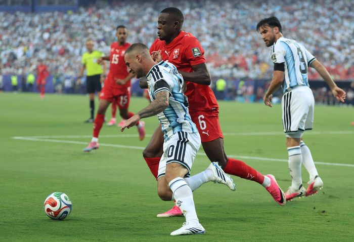 Tiền vệ Argentina Alexis Mac Allister (số 20) tranh bóng với tiền vệ Thụy Sĩ Denis Zakaria (số 6). Ảnh: AFP/TTXVN (Ảnh không cho phép bên thứ 3 khai thác, chia sẻ lại)