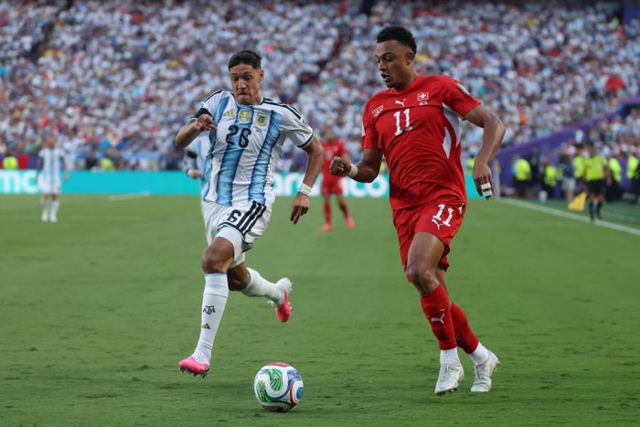 Pha tranh bóng giữa hậu vệ Argentina Nahuel Molina (số 26) và tiền đạo Thụy Sĩ Dan Ndoye (số 11). Ảnh: AFP/TTXVN (Ảnh không cho phép bên thứ 3 khai thác, chia sẻ lại)