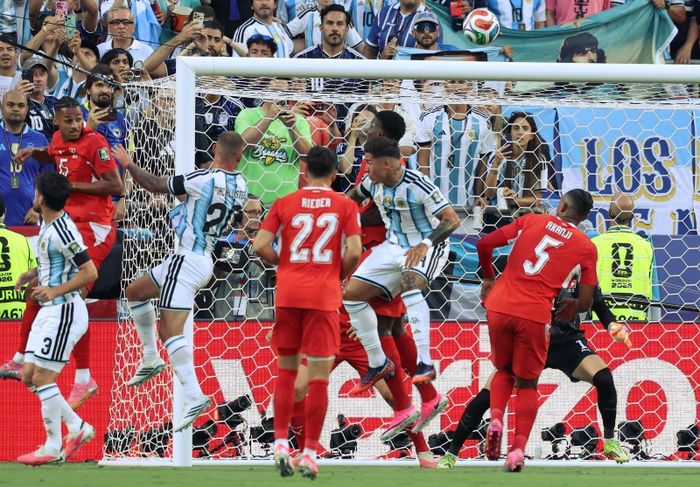 Tiền vệ Alexis Mac Allister (số 20) bật cao đánh đầu hiểm hóc, ghi bàn mở tỉ số cho Argentina ở phút thứ 10. Ảnh: AFP/TTXVN (Ảnh không cho phép bên thứ 3 khai thác, chia sẻ lại)