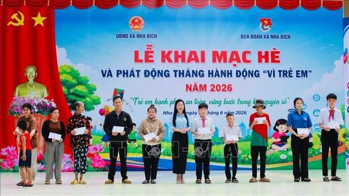 Bà Nguyễn Thị Minh Tiền, Phó Chủ tịch UBND xã Nha Bích trao quà cho trẻ em có hoàn cảnh khó khăn trên địa bàn. Ảnh: Nhật Bình/TTXVN