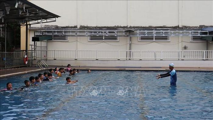 Huấn luyện viên hướng dẫn dạy bơi cho các em học sinh trên địa bàn phường Đồng Xoài hè năm 2026. Ảnh: Nhật Bình/TTXVN