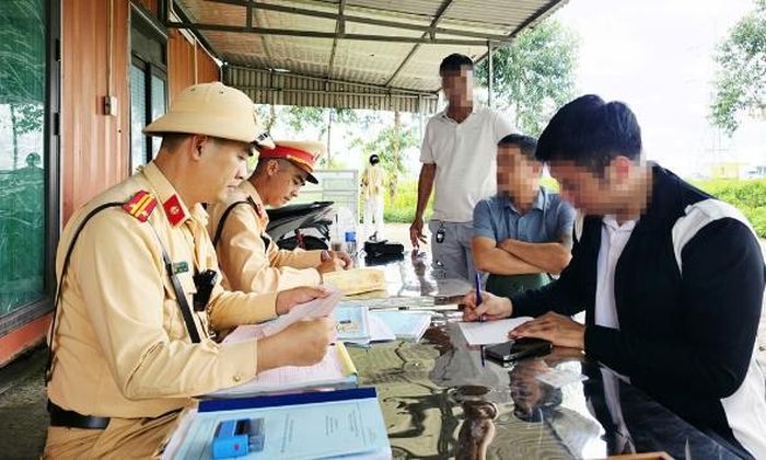 Một tài xế điều khiển phương tiện chạy quá tốc độ ký biên bản vi phạm.