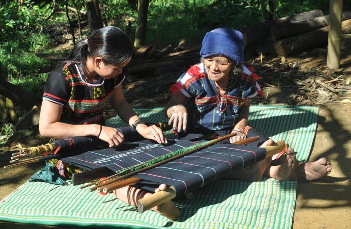 Cụ bà Cơ Tu làng Công Dồn truyền nghề dệt vải hoa văn knuốt cho thợ dệt trẻ.
