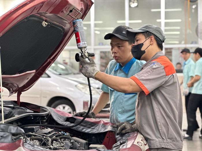 Những giờ thực hành giúp Đoàn Thanh Trí (trái) từng bước làm quen với công việc của một kỹ thuật viên ô tô. Ảnh: NAM BÌNH