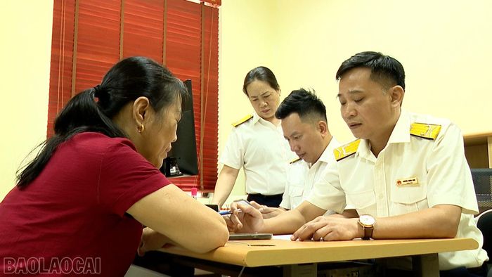 Cán bộ Thuế cơ sở 6 hỗ trợ người dân sử dụng ứng dụng eTax Mobile.