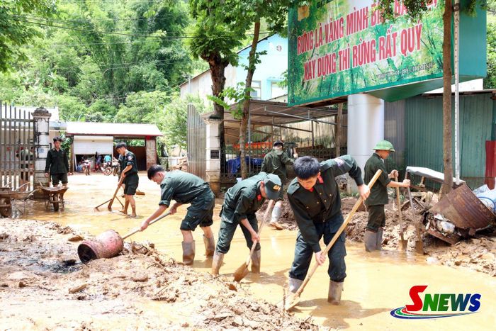 Phòng Cảnh sát cơ động Công an tỉnh Sơn La hỗ trợ người dân dọn dẹp bùn đất sau mưa lũ.