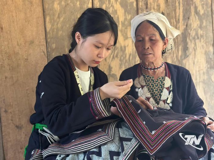 Bà Triệu Thị Xuân tỉ mỉ truyền dạy nghề thêu truyền thống cho cháu gái.
