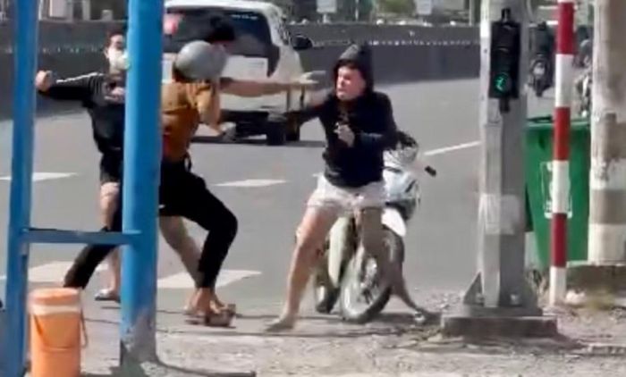 Nam thanh niên dùng mũ bảo hiểm chống trả.