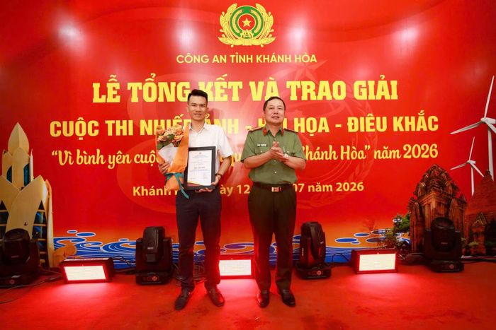 Đại tá Nguyễn Quân, Phó Giám đốc Công an tỉnh Khánh Hòa, Trưởng Ban Tổ chức cuộc thi trao giải nhất lĩnh vực nhiếp ảnh cho tác giả Vương Mạnh Cường. Ảnh: Tiến Quân.