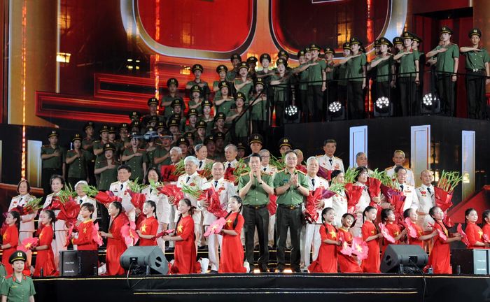 Bộ trưởng Lương Tam Quang và Thứ trưởng Phạm Thế Tùng cùng các chiến sĩ an ninh trẻ tặng hoa các anh hùng thuộc lực lượng An ninh nhân dân.