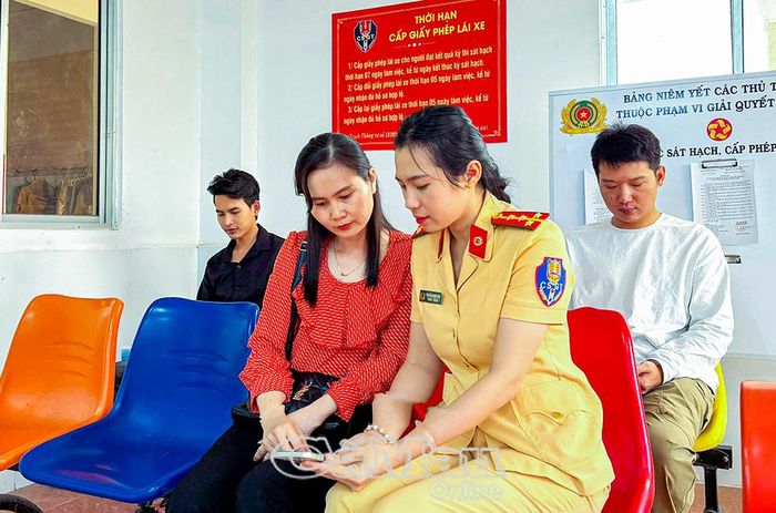 Cán bộ Cảnh sát giao thông hướng dẫn người dân tích hợp giấy phép lái xe trên ứng dụng VNeID và sử dụng ứng dụng VNeTraffic.