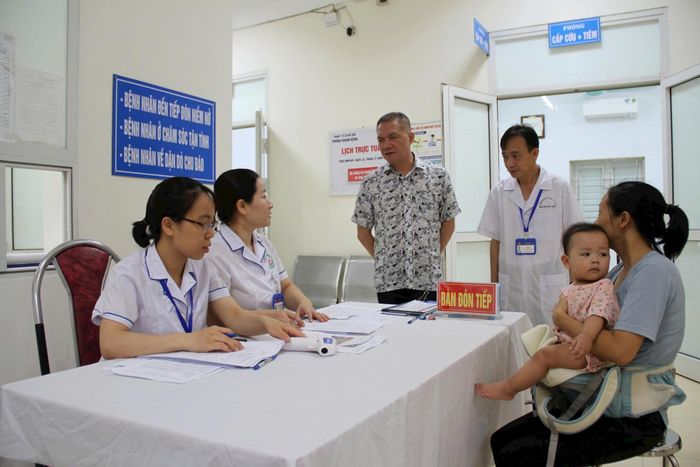 Chủ tịch UBND xã Mỹ Đức Nguyễn Quang Đường thăm hỏi, động viên các y, bác sĩ và người dân tham gia khám sức khỏe tại Trạm Y tế xã Mỹ Đức. Ảnh: Biên Phạm
