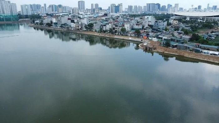 Nhìn từ mặt hồ, phía sau là hàng loạt tòa nhà cao tầng của khu vực Mỹ Đình - Từ Liêm. Hồ điều hòa không chỉ có chức năng chống ngập mà còn được định hướng trở thành không gian sinh thái, cải thiện cảnh quan đô thị.