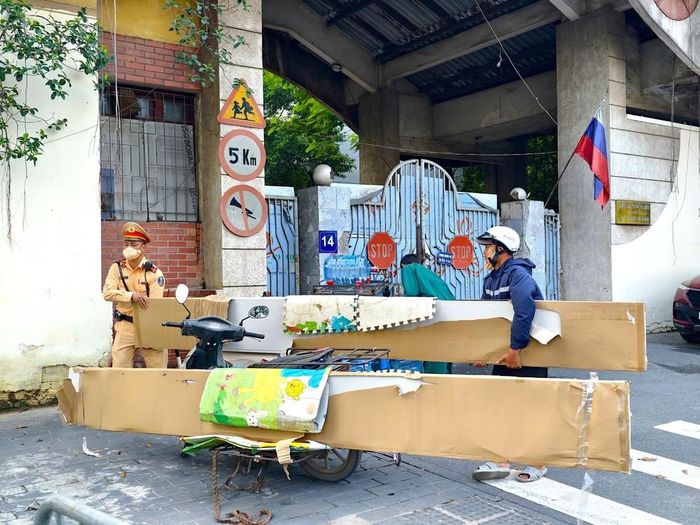 Cán bộ Đội Cảnh sát giao thông số 7 yêu cầu người điều khiển phương tiện sắp xếp lại hàng hóa, bảo đảm không che khuất biển kiểm soát. Ảnh: Trung Nguyên - TTXVN