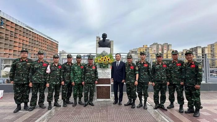Đại sứ Vũ Trung Mỹ và Thiếu tướng Phạm Văn Tỵ, Phó Cục trưởng Cục Cứu hộ - cứu nạn (Bộ Tổng Tham mưu, Quân đội nhân dân Việt Nam),Trưởng đoàn công tác và các thành viên Đoàn công tác của Quân đội Nhân dân Việt Nam chụp ảnh kỷ niệm bên Tượng đài Chủ tịch Hồ Chí Minh.