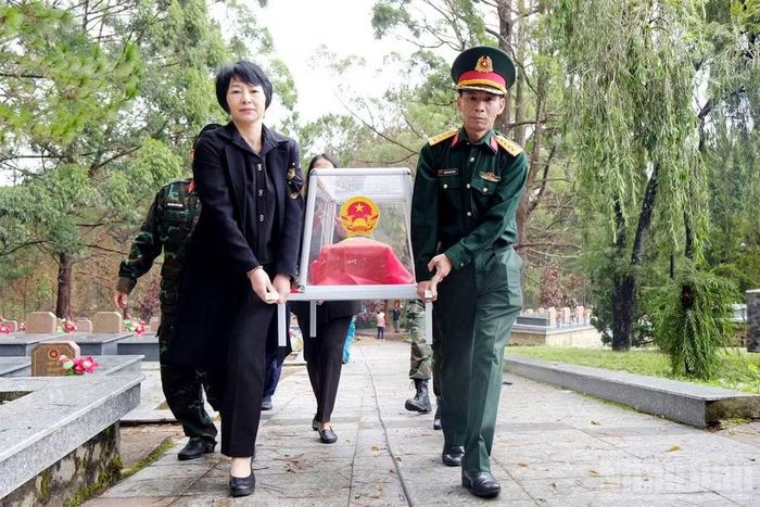 Đồng chí Phạm Thị Phúc và Đại tá Nguyễn Thanh Quảng, Phó Chính ủy Bộ Chỉ huy Quân sự tỉnh, Phó Trưởng Ban Chỉ đạo 515 tỉnh Lâm Đồng thực hiện nghi thức đưa hài cốt liệt sĩ đến khu vực lấy mẫu.