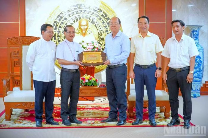 Lãnh đạo tỉnh Cà Mau (bên phải) tặng quà lưu niệm cho đại diện đoàn của Tòa Giám mục Cần Thơ.