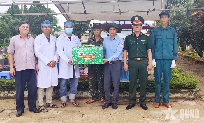 Thiếu tướng Lương Đình Chung (thứ hai, từ phải sang) trao quà tặng lực lượng thực hiện nhiệm vụ lấy mẫu sinh phẩm tại Nghĩa trang Liệt sĩ Đức Cơ.