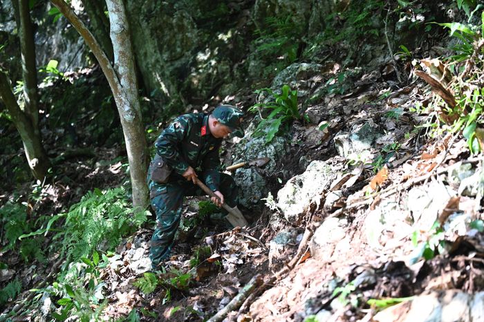 Trên vách núi, Trung úy Vàng Seo Páo dùng xẻng tỉ mỉ đào từng tấc đất nhỏ để tìm kiếm hài cốt liệt sĩ