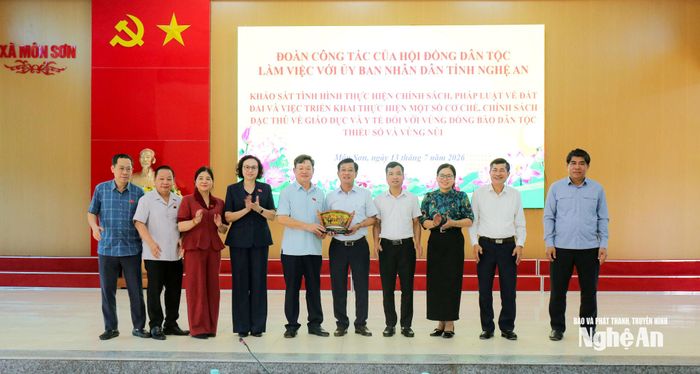 Đoàn công tác trao quà lưu niệm cho UBND xã Môn Sơn. Ảnh: Bá Hậu