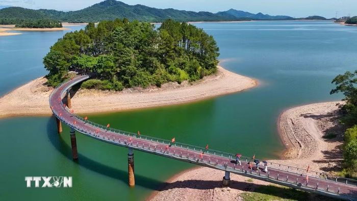 Cây cầu dẫn vào hòn đảo nơi có Đền thờ cố Tổng Bí thư Lê Duẩn. (Ảnh: Hữu Quyết/TTXVN)