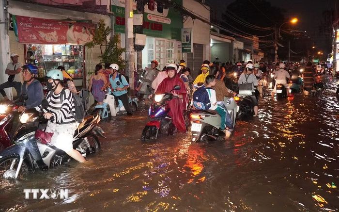 Người dân chật vật dắt bộ trên một con đường tại phường Bình Quới, thành phố Hồ Chí Minh trong chiều 11/5/2025. (Ảnh: Trung Tuyến/TTXVN)