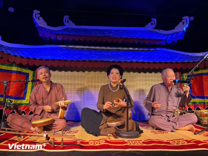 Nghệ sỹ nhân dân Xuân Hoạch (phải); Thạc sỹ nghệ thuật, nghệ nhân Tạ Hạnh (giữa) và nghệ sỹ Trần Koóng trình diễn trong không gian đậm dấu ấn văn hóa truyền thống của Cadao Collective. (Ảnh: Mai Mai/Vietnam+)