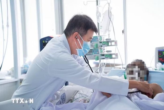 Bác sỹ Trần Thanh Linh, Trưởng Khoa Hồi sức tích cực, Bệnh viện Chợ Rẫy, điều trị cho nạn nhân. (Ảnh: TTXVN phát)