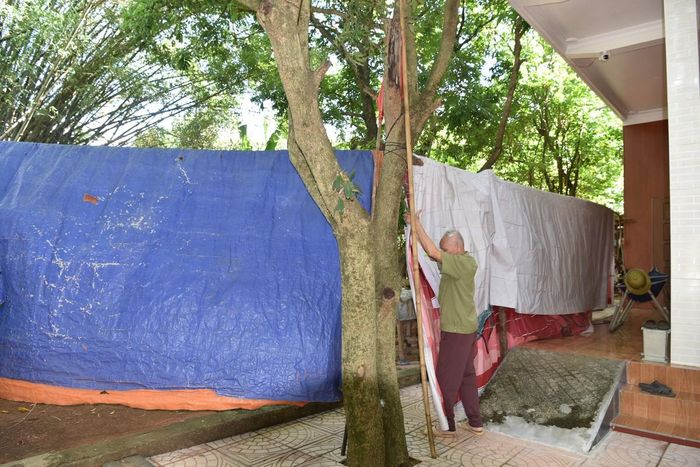 Mỗi lần mỏ đá chuẩn bị đến giờ nổ mìn ông Ngôn lại phải che chắn nhà cửa bằng bạt