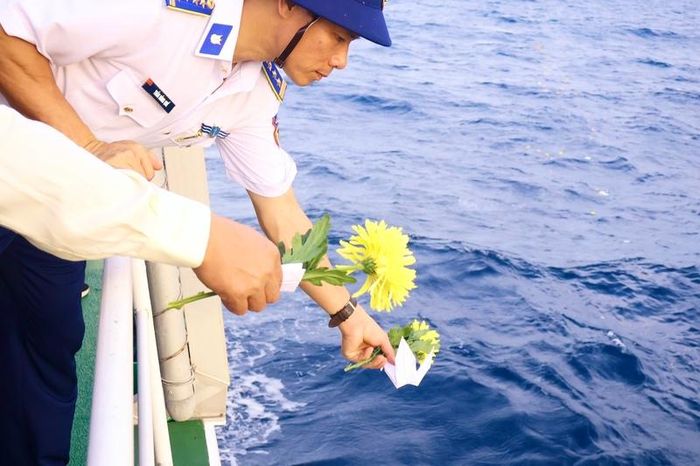 Các đại biểu thả hoa và hạc giấy như một lời tri ân gửi đến các chiến sĩ đã anh dũng hi sinh. Ảnh: Diễm Phúc