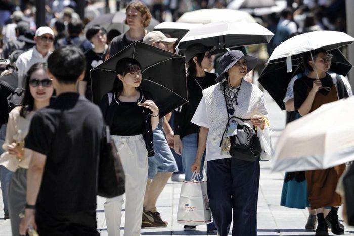 Người dân mang ô khi đi bộ dưới cái nắng mùa hè gay gắt tại khu vực Dazaifu (tỉnh Fukuoka, Nhật Bản). Ảnh: Kyodo News
