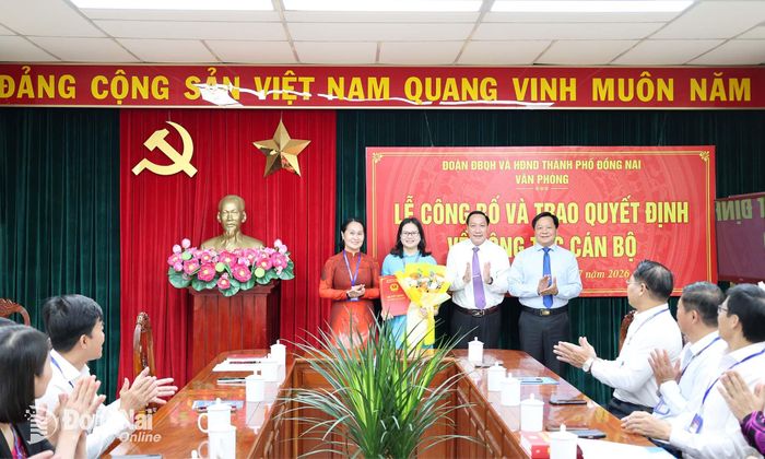 Lãnh đạo Thường trực HĐND thành phố và Đoàn đại biểu Quốc hội thành phố trao quyết định và tặng hoa chúc mừng bà Nguyễn Thị Hương. Ảnh: Hồ Thảo