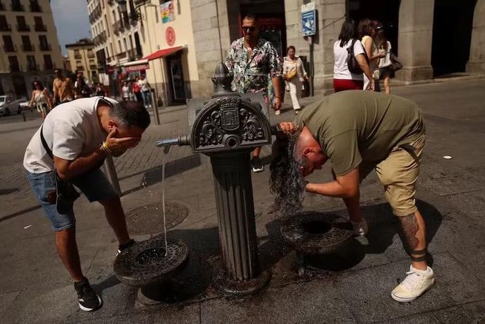 Người dân giải nhiệt tại một đài phun nước trong đợt nắng nóng ở Madrid, Tây Ban Nha, ngày 7 -7-2026. Ảnh: Reuters