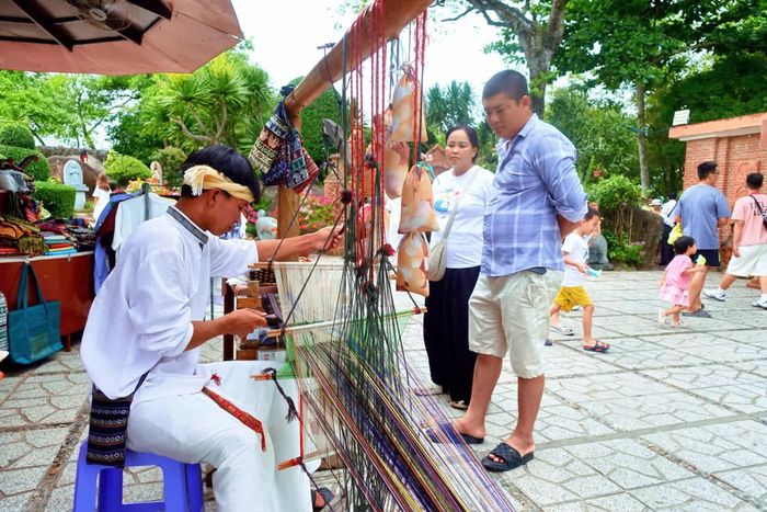 Nhiều du khách thích thú, theo dõi quá trình dệt thổ cẩm Chăm được thực hiện tại Tháp Bà Pô Nagar.