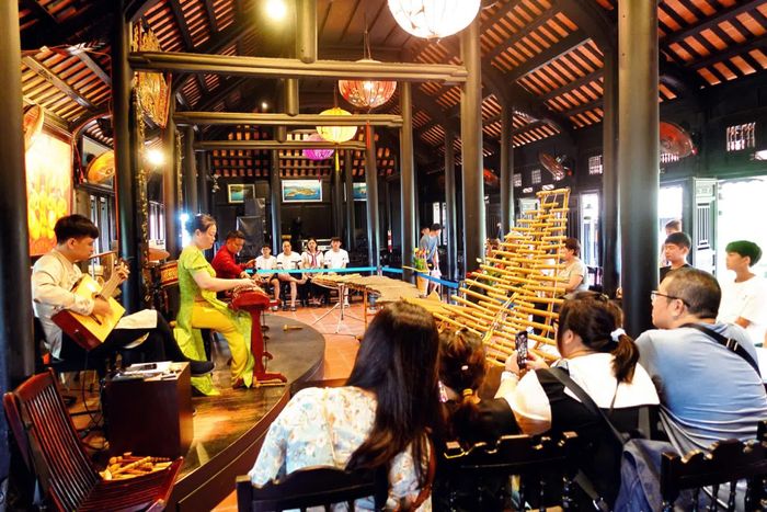 Du khách thưởng thức chương trình biểu diễn nhạc cụ dân tộc tại Hội quán - Danh thắng Hòn Chồng.