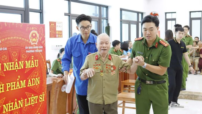 Cán bộ, chiến sĩ công an và đoàn viên hỗ trợ các thân nhân già yếu.