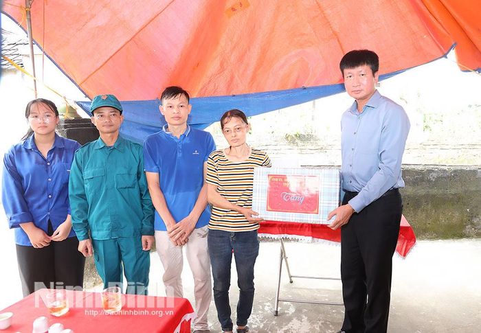 Đồng chí Trần Huy Tuấn, Ủy viên Trung ương Đảng, Bí thư Tỉnh ủy, Bí thư Đảng ủy Quân sự tỉnh tặng quà chị Phạm Thị Nga ở thôn Trung Hòa, xã Yên Mô.