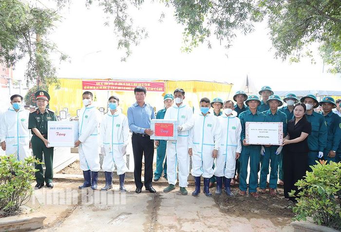 Đồng chí Trần Huy Tuấn, Ủy viên Trung ương Đảng, Bí thư Tỉnh ủy, Bí thư Đảng ủy Quân sự tỉnh; Trung tướng Lương Văn Kiểm, Tư lệnh Quân khu 3 và lãnh đạo xã tặng quà các cán bộ, chiến sĩ, lực lượng chuyên môn đang thực hiện nhiệm vụ tại Nghĩa trang liệt sĩ xã Yên Mô.