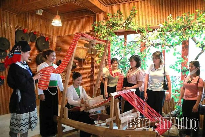 Du khách tham quan, trải nghiệm nghề dệt thổ cẩm của người Mường xã Xuân Đài.